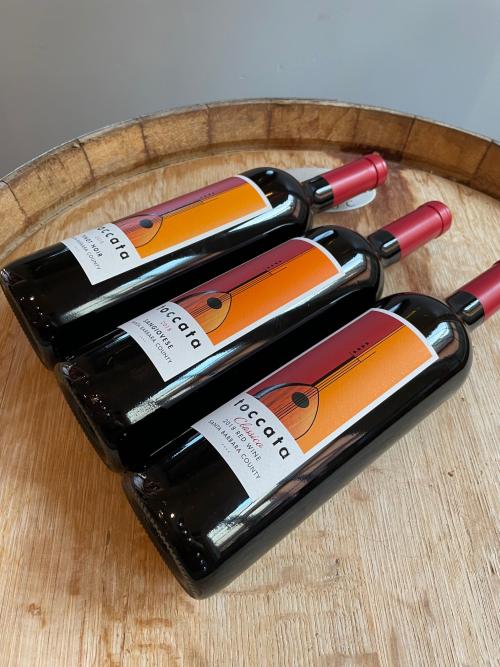 Three bottles of Toccata wine on a wine barrel Three bottles of Toccata wine on a wine barrel