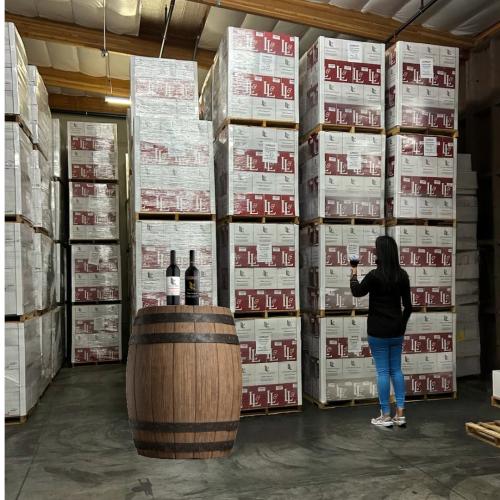 Woman standing in front of case of wine - Wine Pull warehouse wine sale Woman standing in front of case of wine - Wine Pull warehouse wine sale