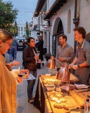 Photo by Downtown Live Organization Art & Wine - guest with glass of wine on patio tasting flatbreads made by two local chefs