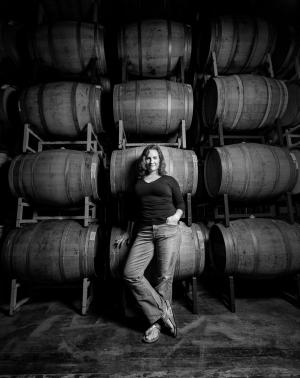 Winemaker Megan standing with barrels in black and white